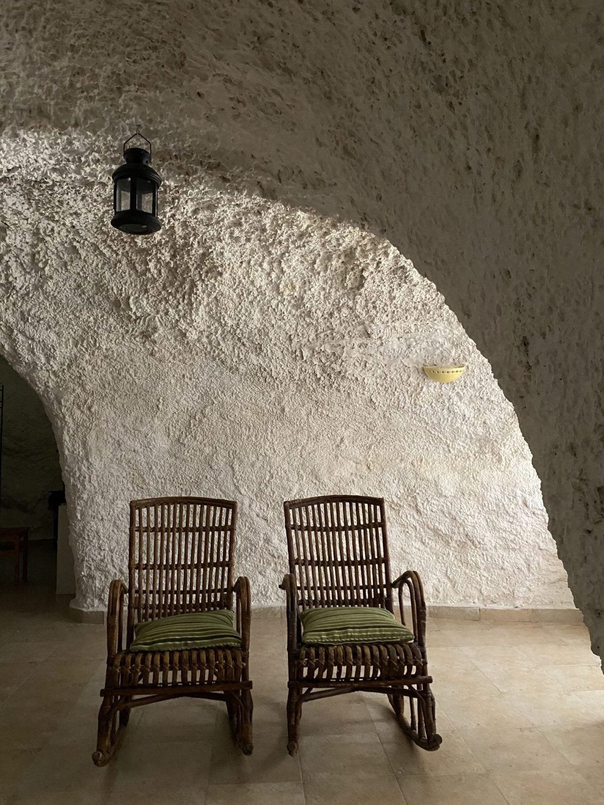 Interior encalado de una casa cueva con dos mecedoras