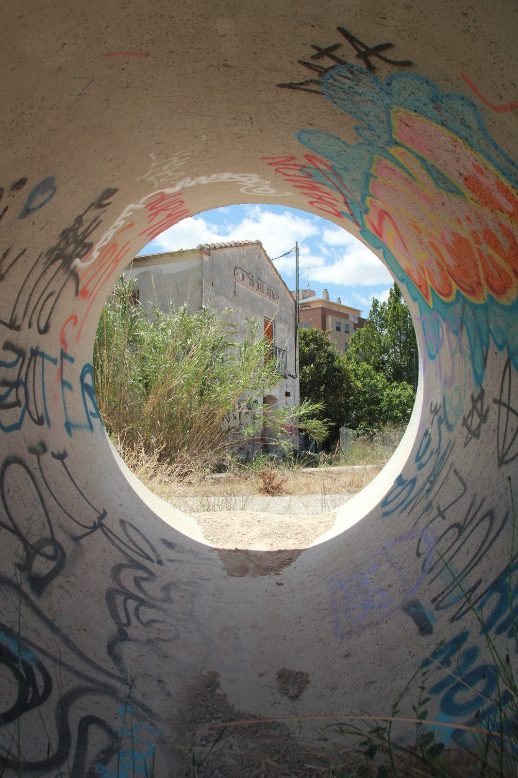 Tubo de hormigón lleno de pintadas por el que discurre el agua