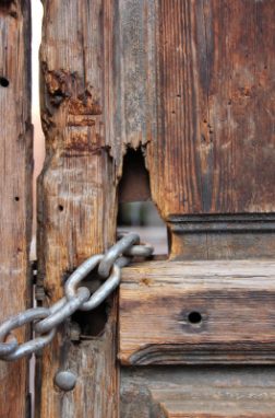 Detalle de la puerta de madera con una cadena