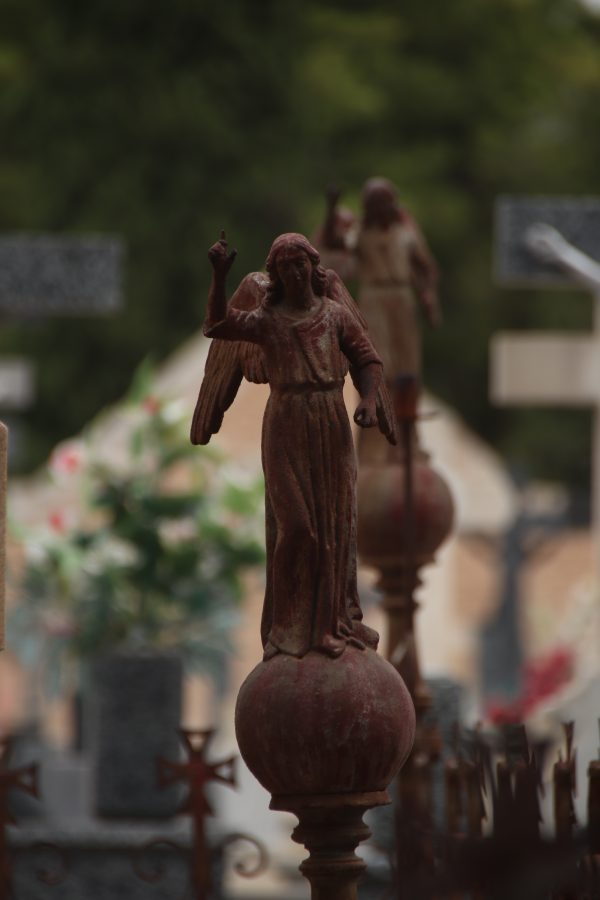 Ángel de hierro sobre la verja del cementerio