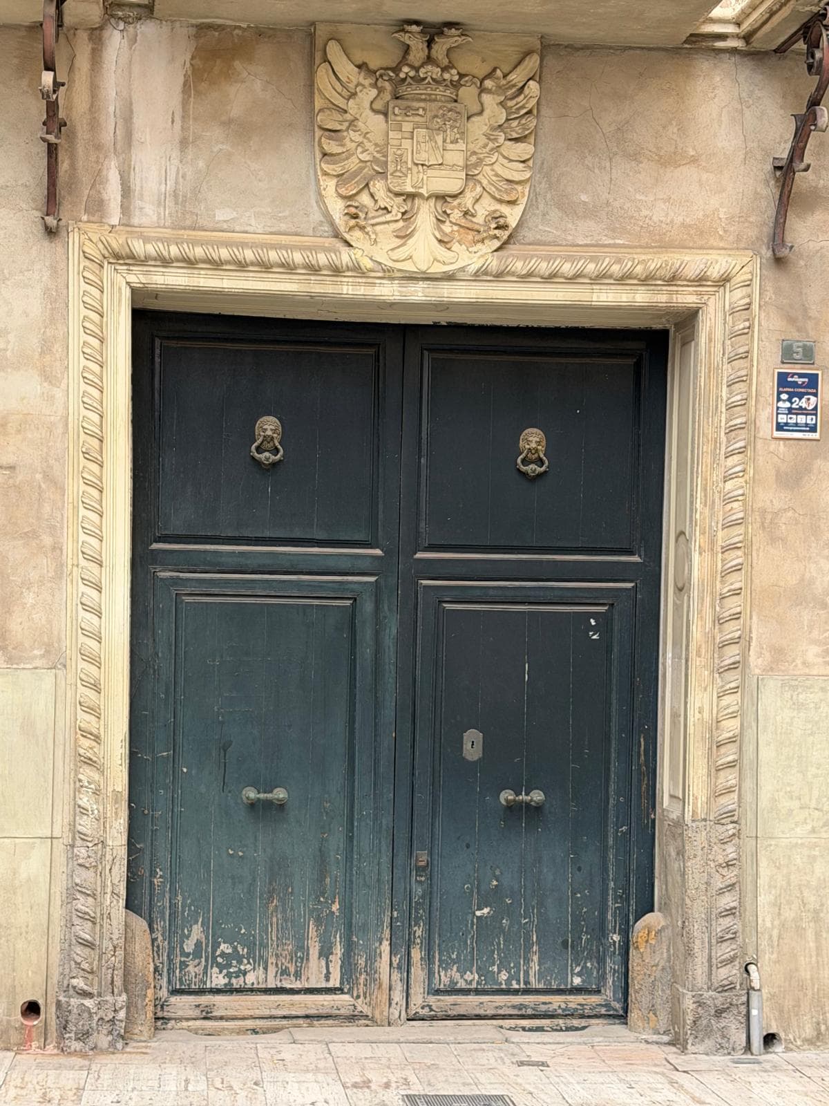 Portada del palacio, con el escudo nobiliario sobre la puerta de madera